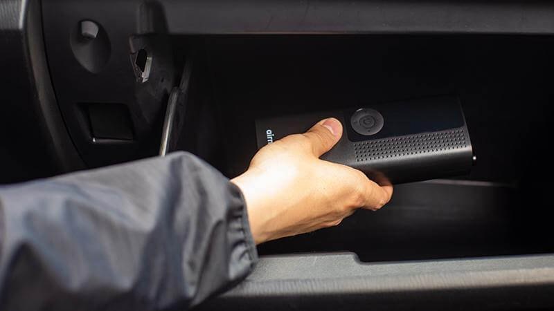 A compact tire inflator stored in a vehicle glove compartment